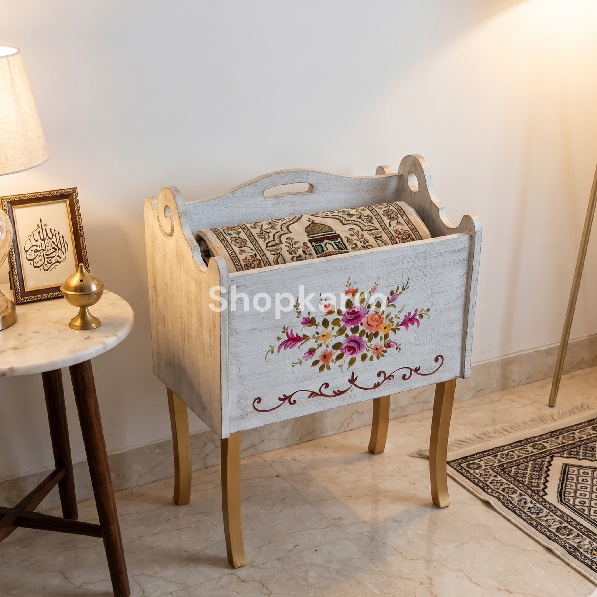 Hand-painted white wooden jaaye namaz box displayed in peaceful home prayer corner with folded prayer mat inside