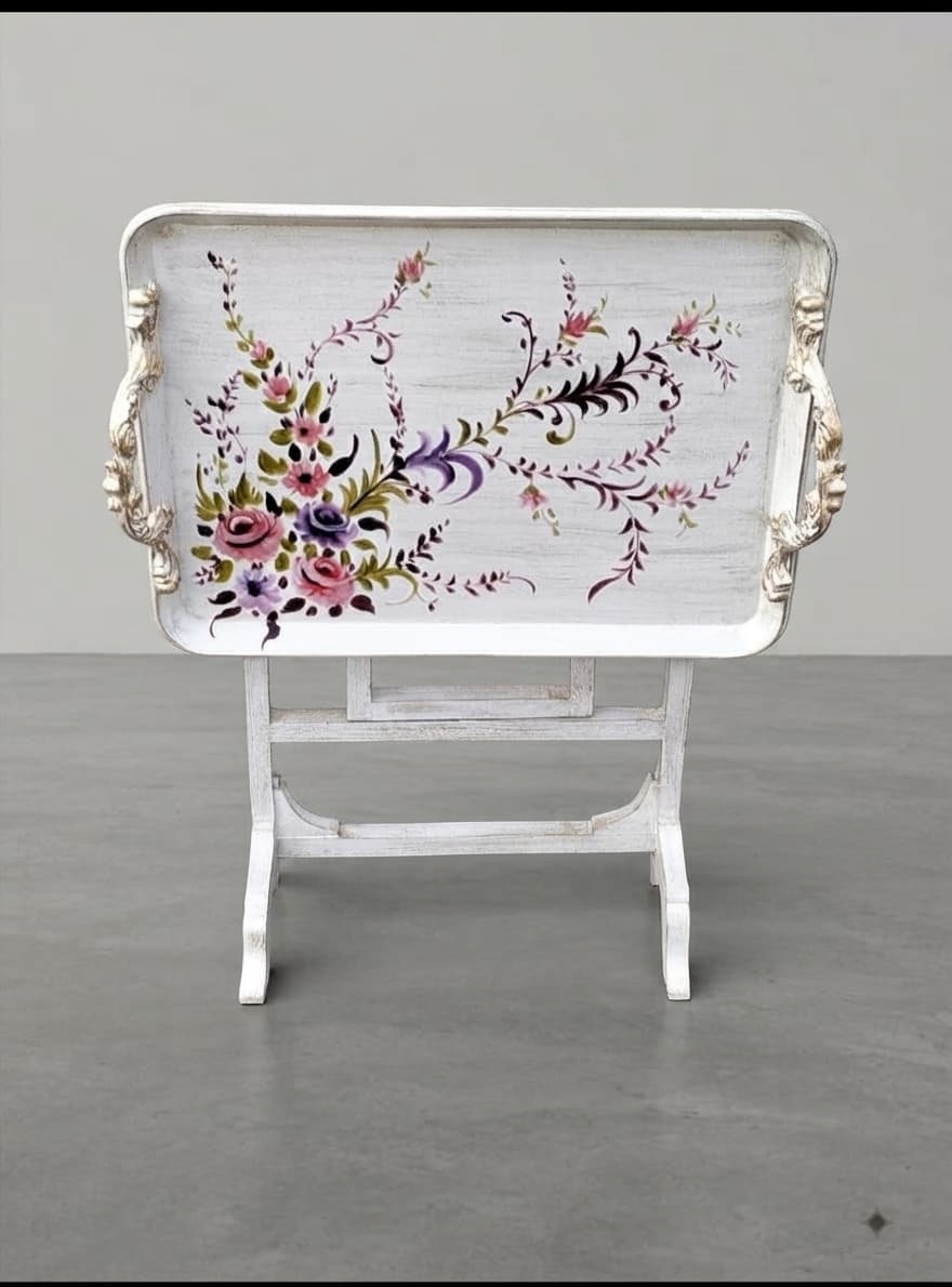 Ornate carved handles and X-frame folding legs of Heirloom Petal tray table
