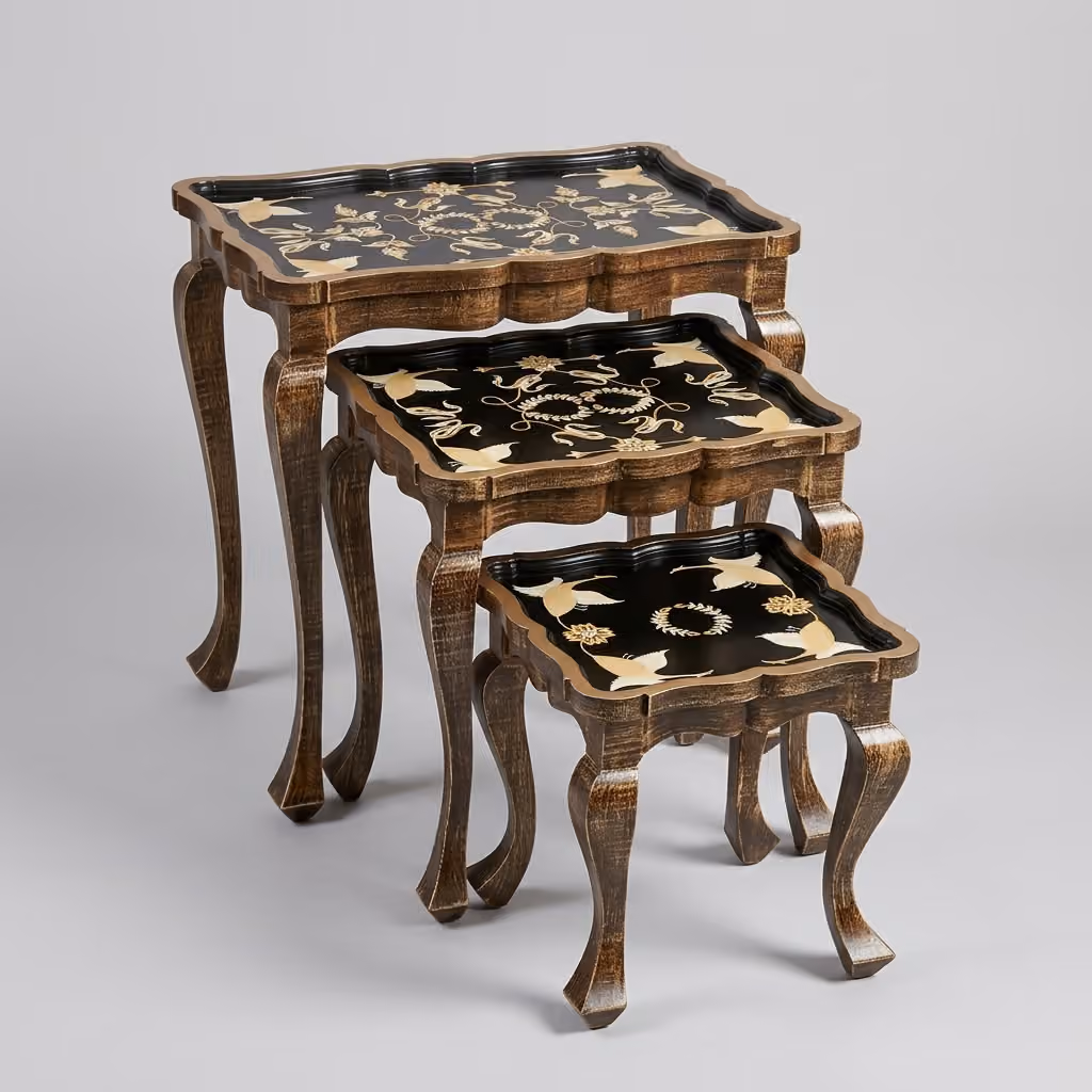 Close-up of hand-painted golden crane and floral design on black lacquered Vintage Gold Nesting Table top